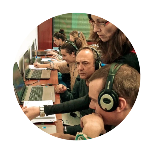 Práctica con simulador del curso de Operador restringido del SMSSM: alumnos con auriculares frente a los portátiles, con la instructora al lado.