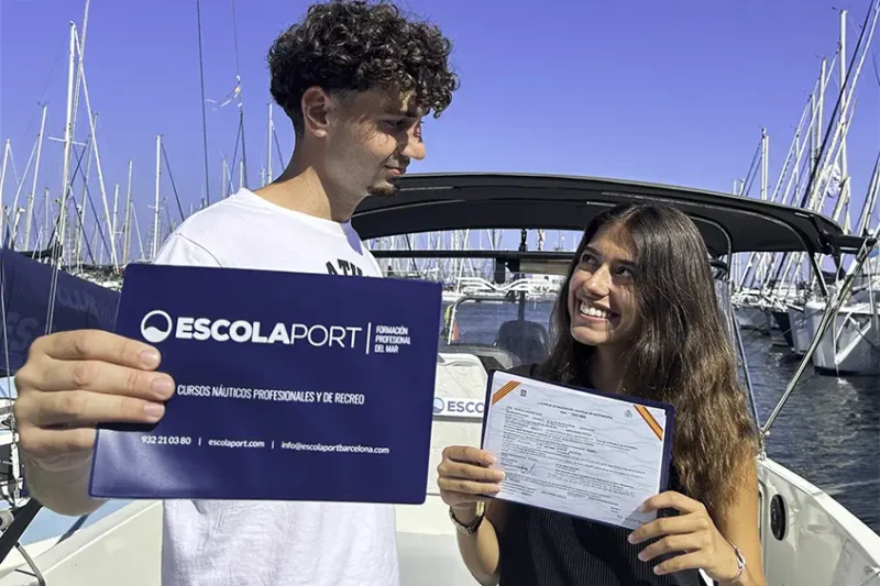 Pareja de estudiantes con su Licencia de navegación obtenida en Escola Port Pareja de estudiantes con su Licencia de navegación obtenida en Escola Port