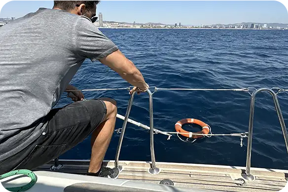 Práctica de seguridad y maniobra de persona en el agua con aro salvavidas durante las prácticas de navegación a vela