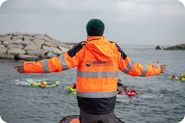 Formació marítima professional STCW a Escola Port Barcelona durant una pràctica de seguretat al mar amb instructor i alumnes.