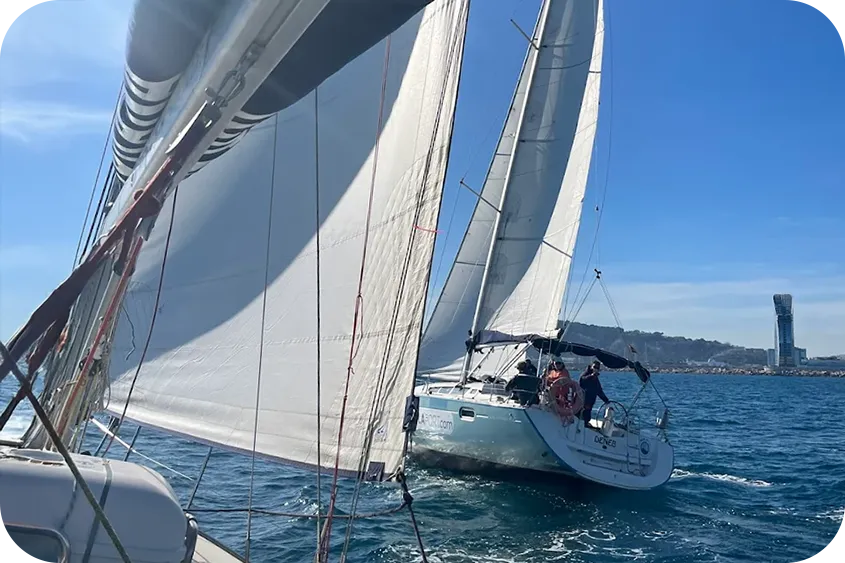 Alumnos haciendo prácticas de navegación a vela a boro de veleros de Escola Port