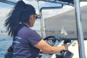 Alumna al timón durante las prácticas de la licencia de navegación en el Port Olímpic