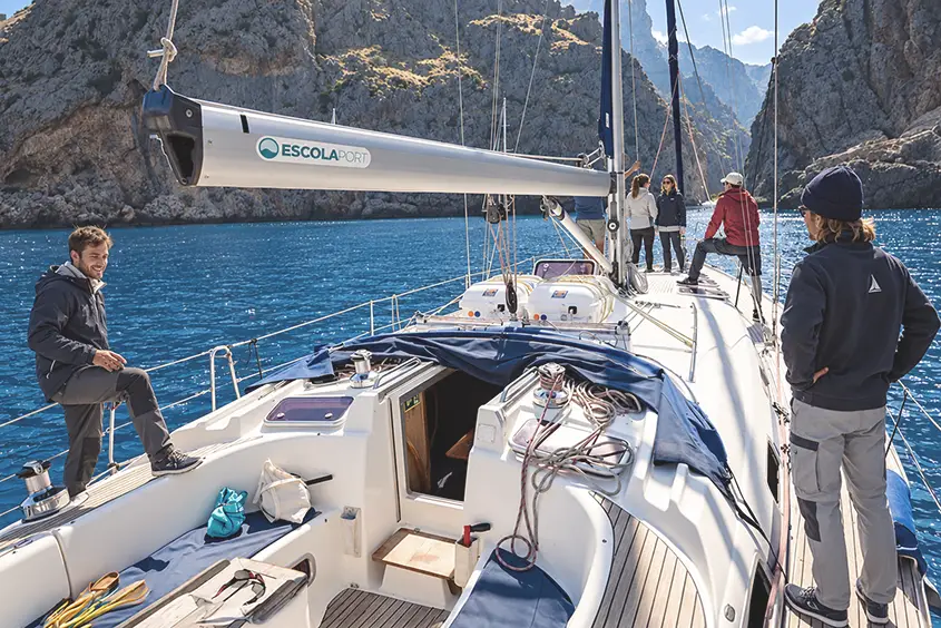 Arribada a Sa Calobra durant les pràctiques del PER a bord: la gent a coberta del veler, davant els penya-segats.